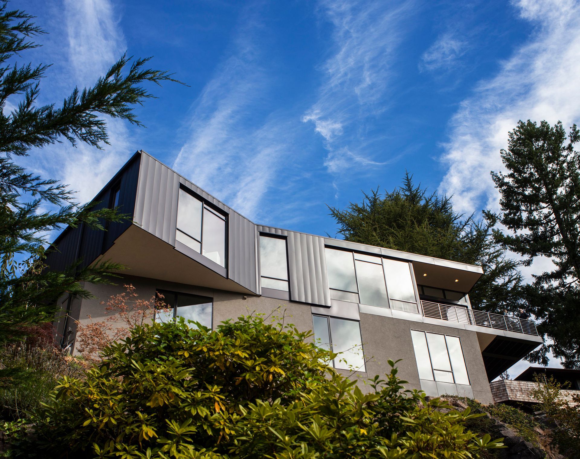 A large house on a hill with trees in front of it