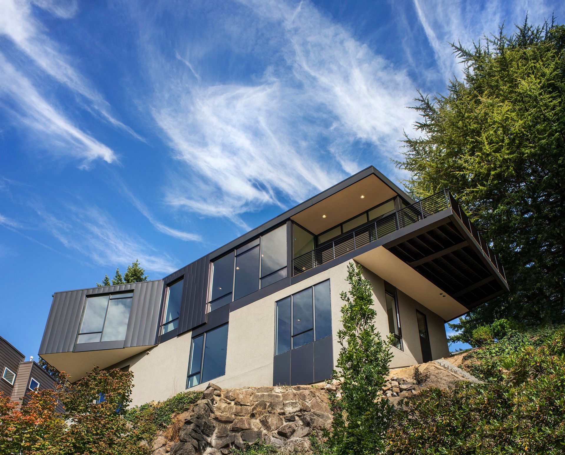 A large house is sitting on top of a hill surrounded by trees.