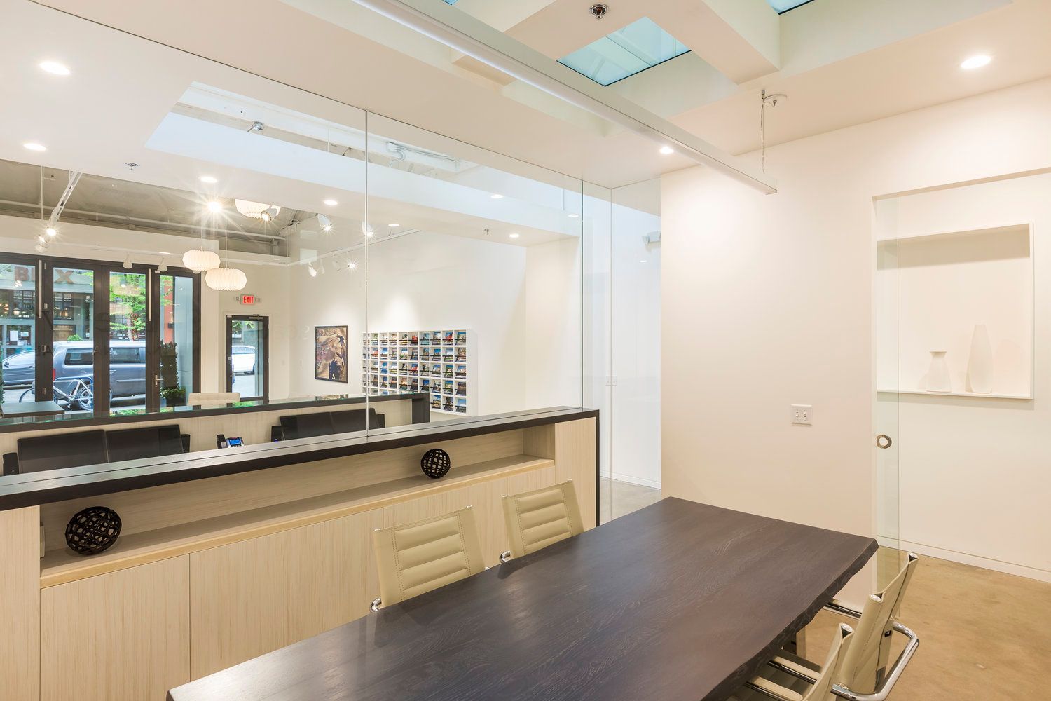 A conference room with a table and chairs and a glass wall.