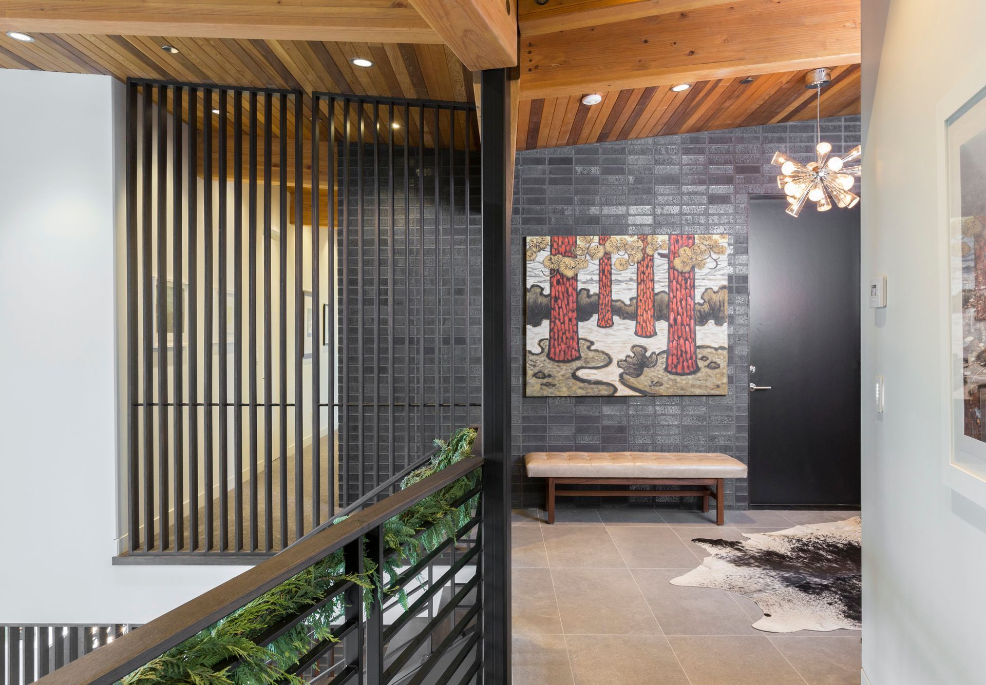 A hallway with a painting on the wall and a bench.