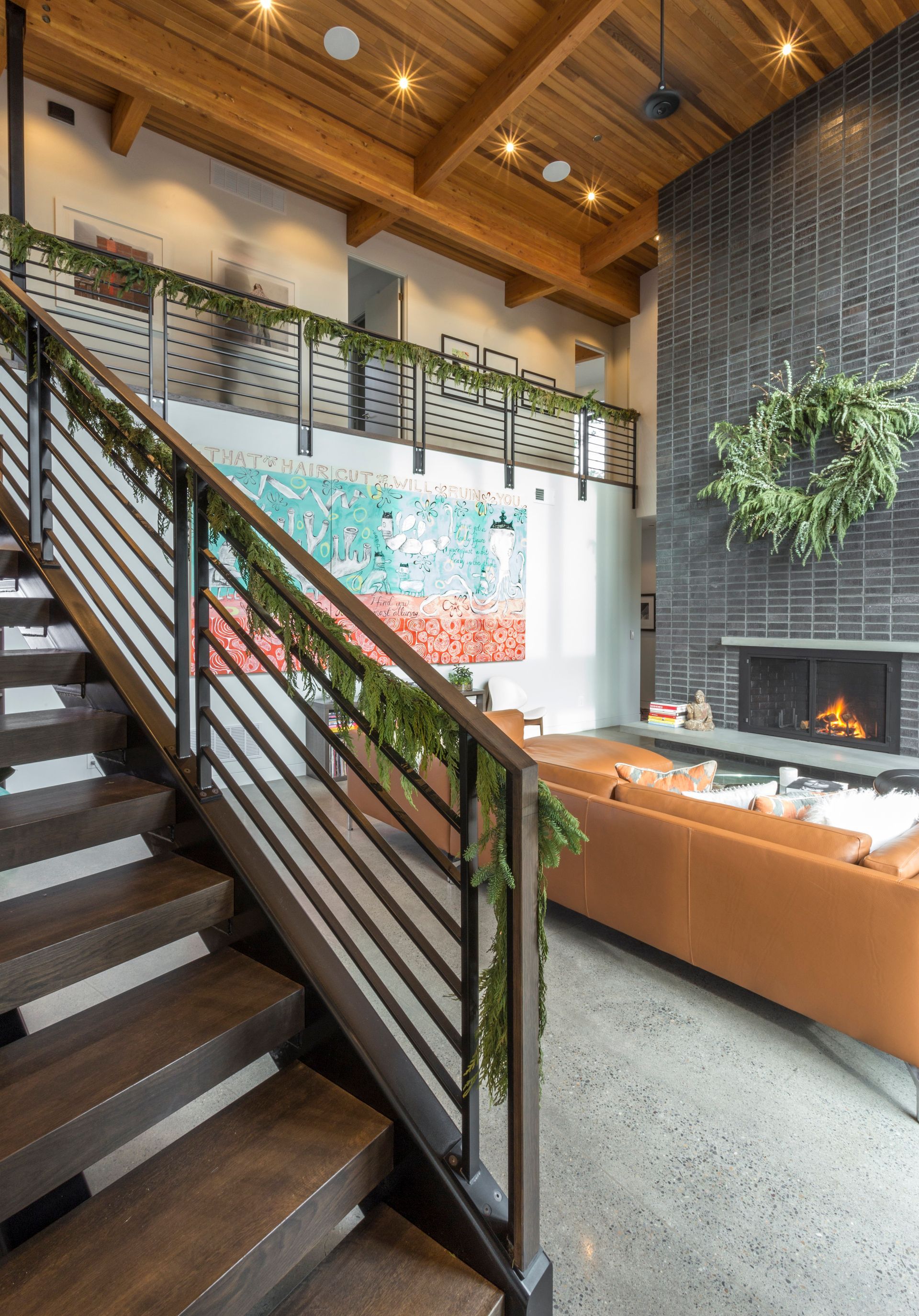 A living room with stairs leading up to the second floor and a fireplace.