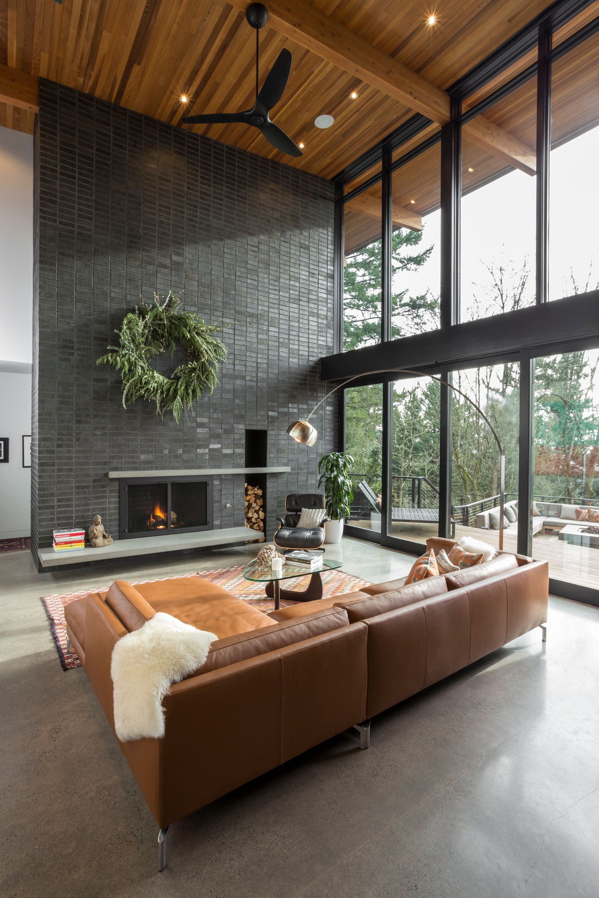 A living room with a couch , fireplace , and lots of windows.
