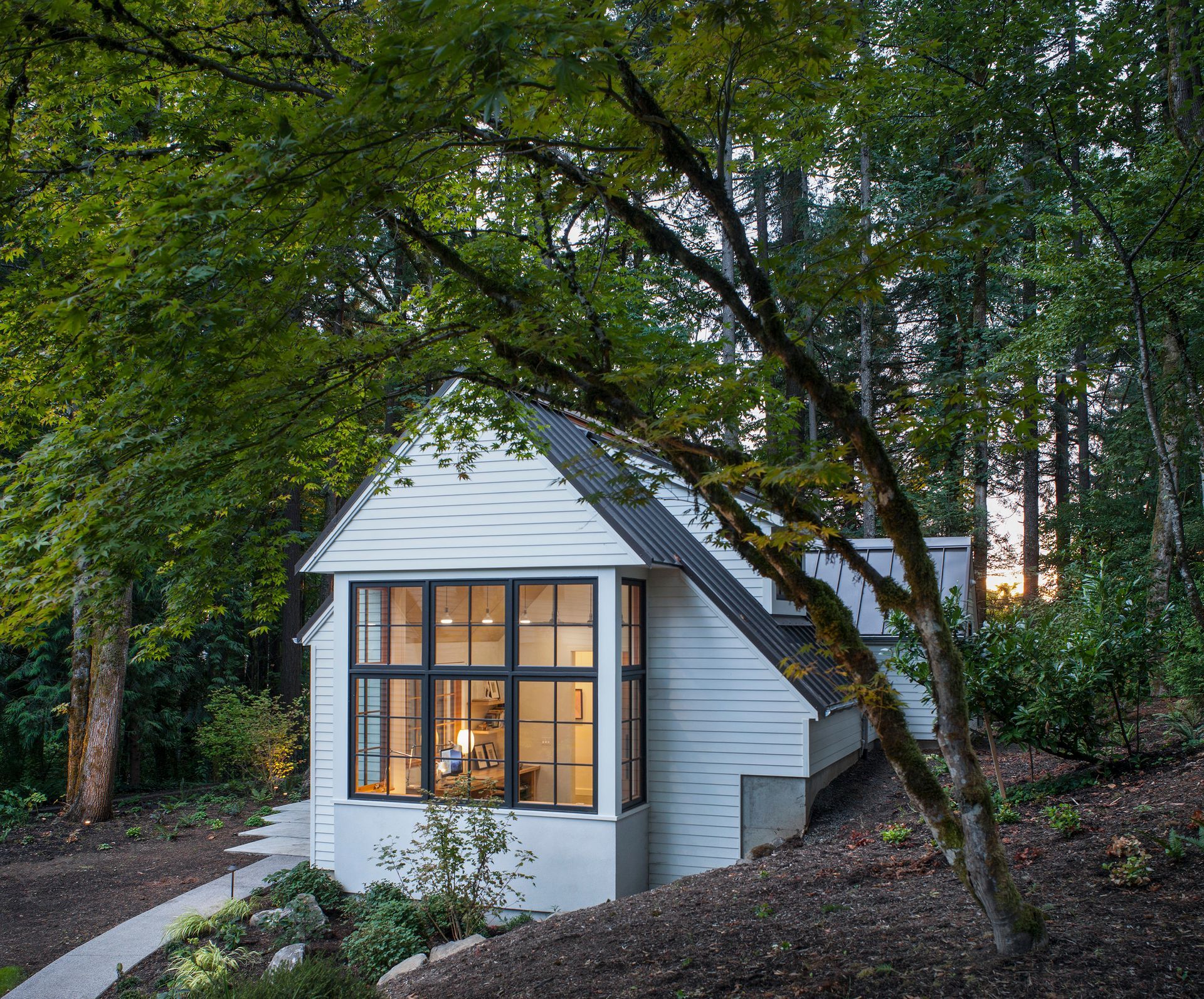 A small white house in the middle of a forest