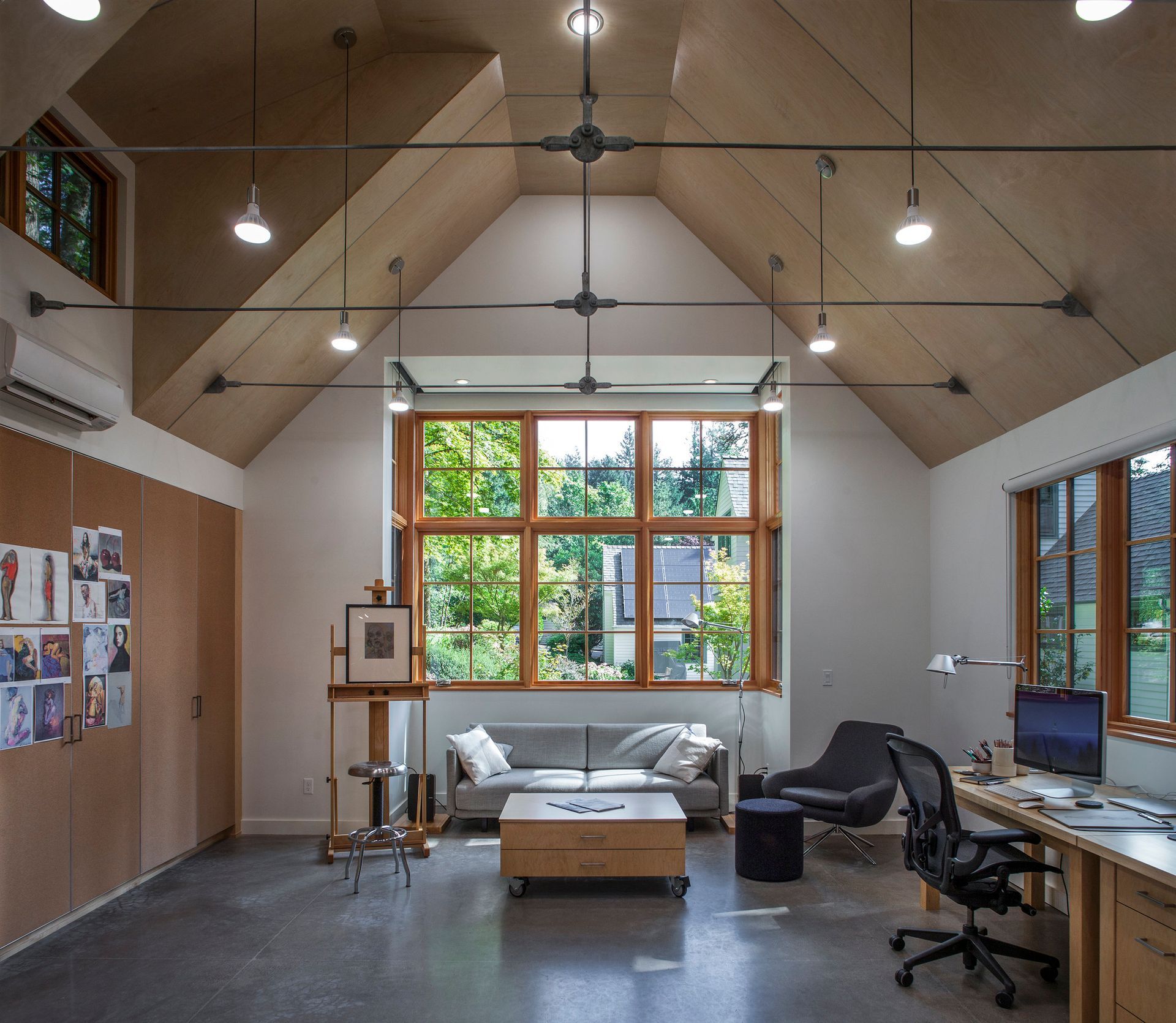 A living room with a vaulted ceiling and lots of windows
