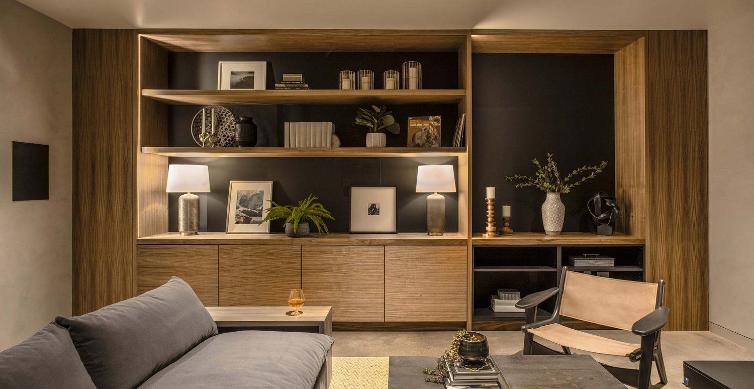 A living room with a couch , chair , table and shelves.