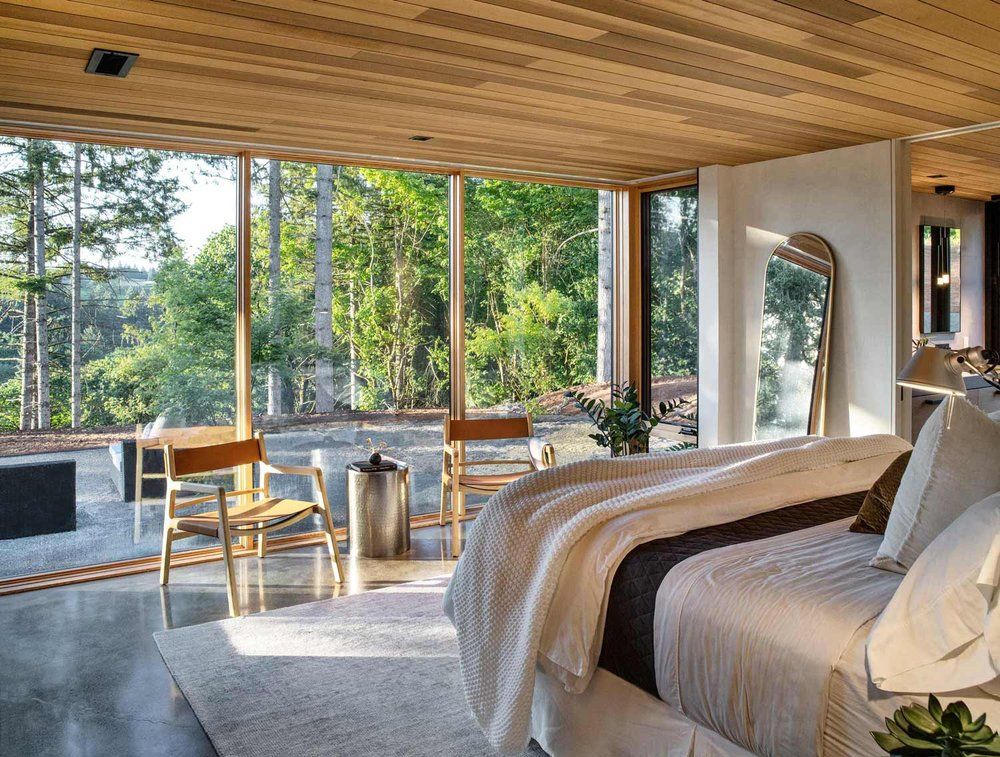 A bedroom with a large bed and lots of windows.