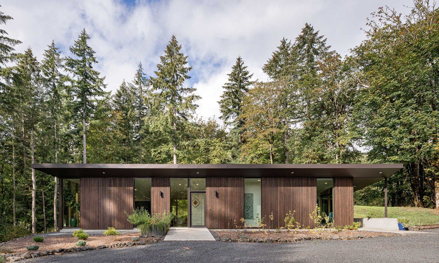 A small house is sitting in the middle of a forest.