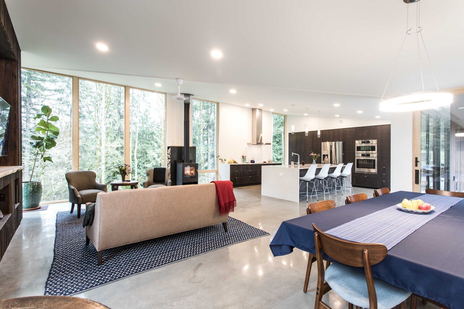 A living room and dining room in a house with a table and chairs.