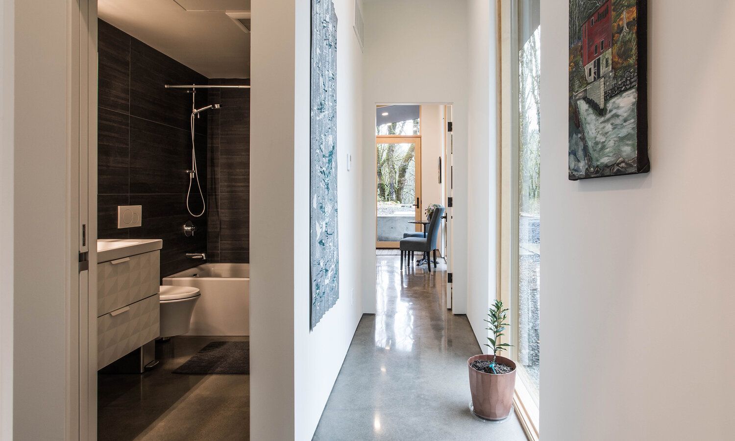 A long hallway leading to a bathroom and a dining room.