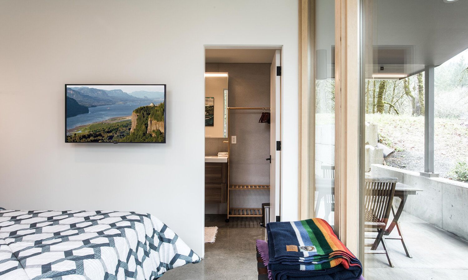 A bedroom with a bed and a television on the wall.
