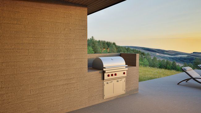 A grill is built into the side of a building on a patio.