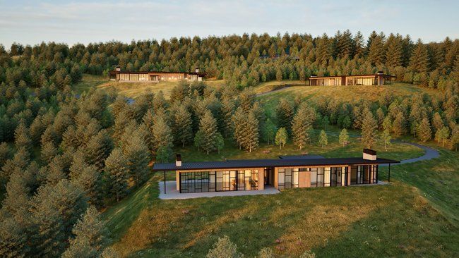 An aerial view of a house on a hill in the middle of a forest.