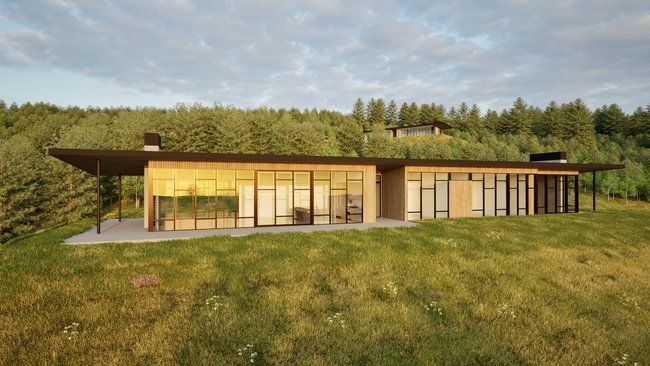 house in the middle of a field surrounded by trees.