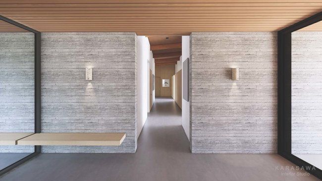 A hallway in a house with concrete walls and a wooden ceiling.