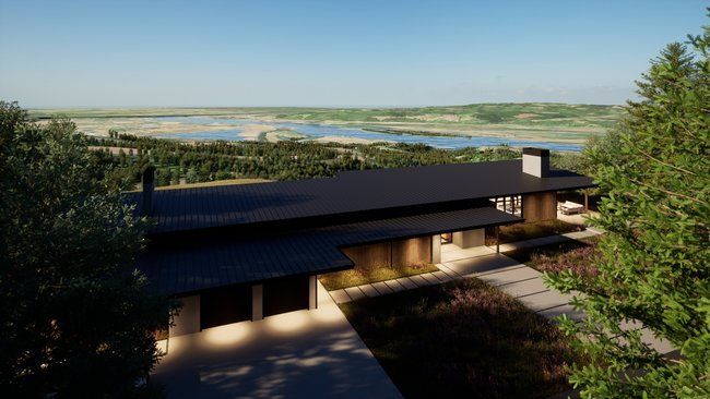 An aerial view of a house on a hill overlooking a lake surrounded by trees.
