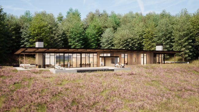 house is sitting in the middle of a field surrounded by trees.