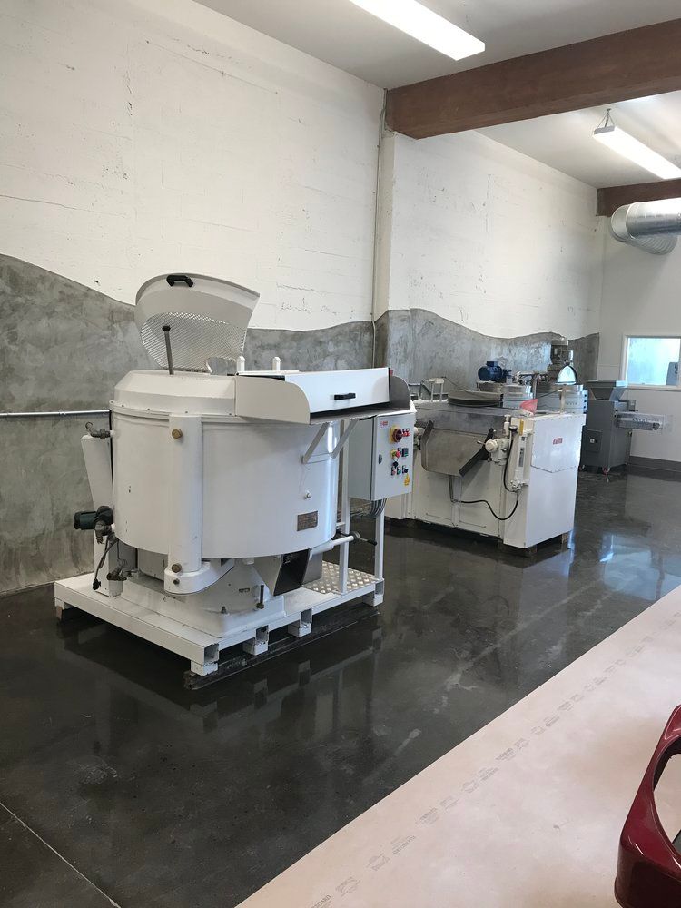 A room with two mixers in it and a red car in the background.