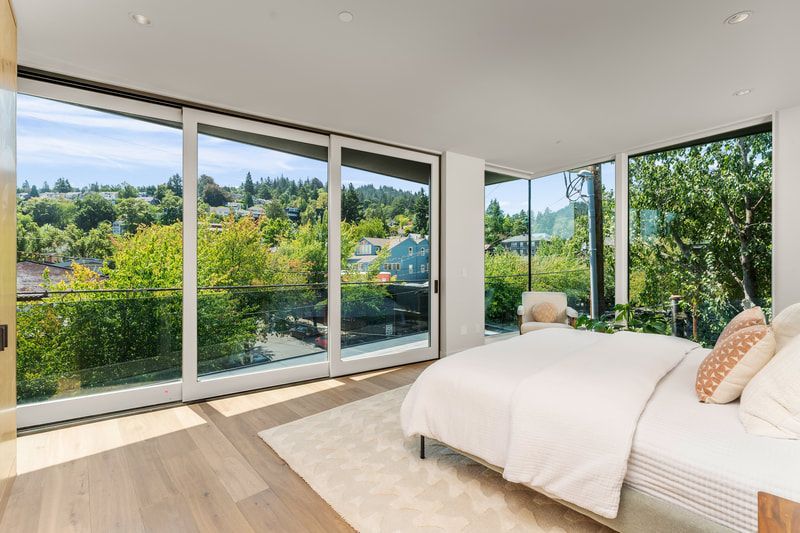A bedroom with a large bed and lots of windows.