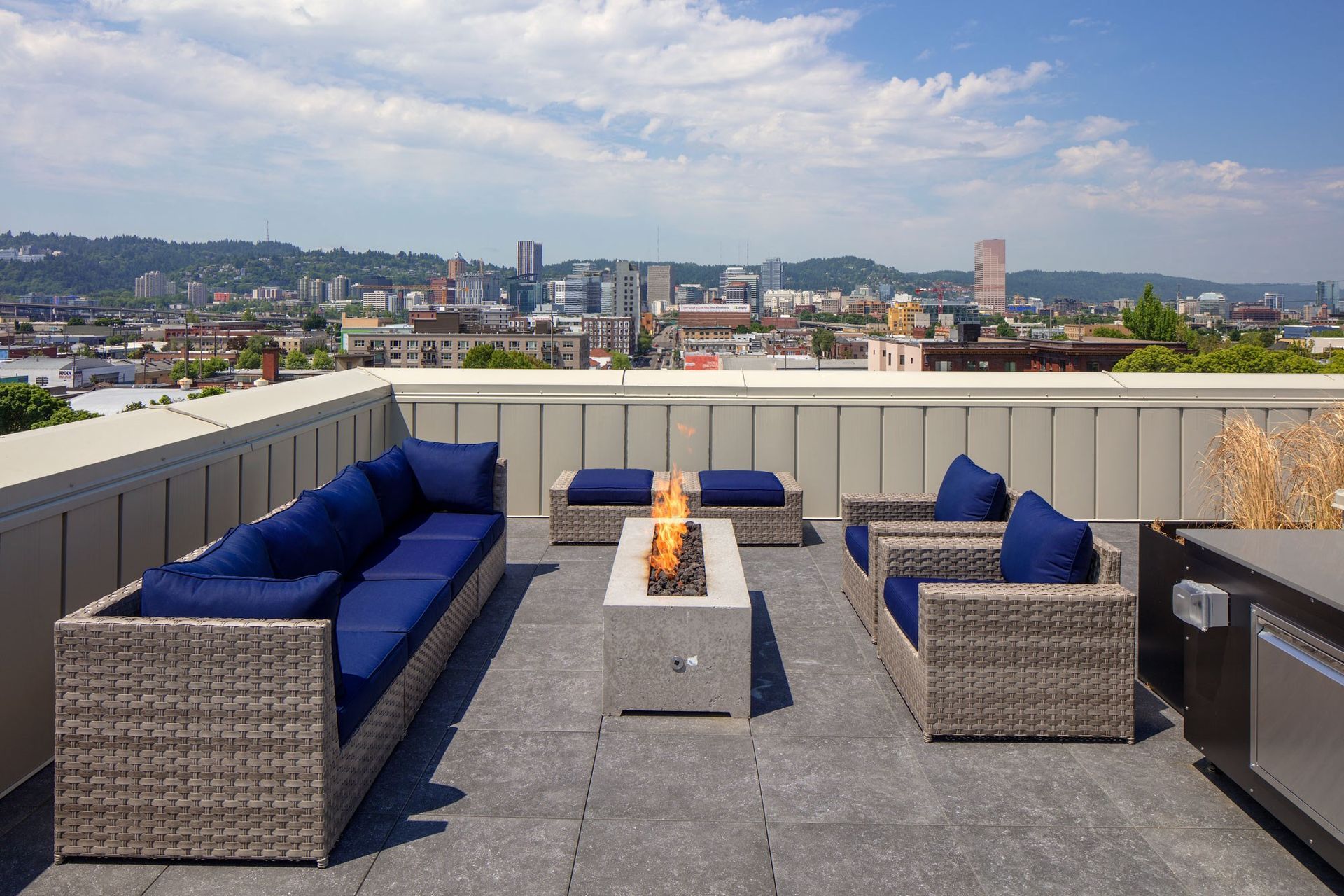 A patio with a fire pit and a view of the city