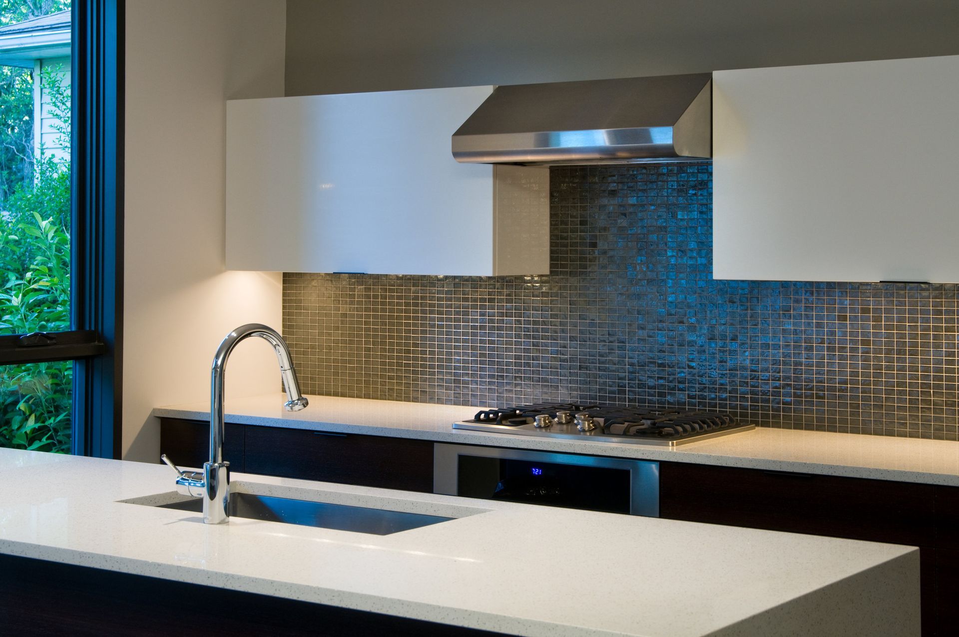 A kitchen with a sink and a stove top oven