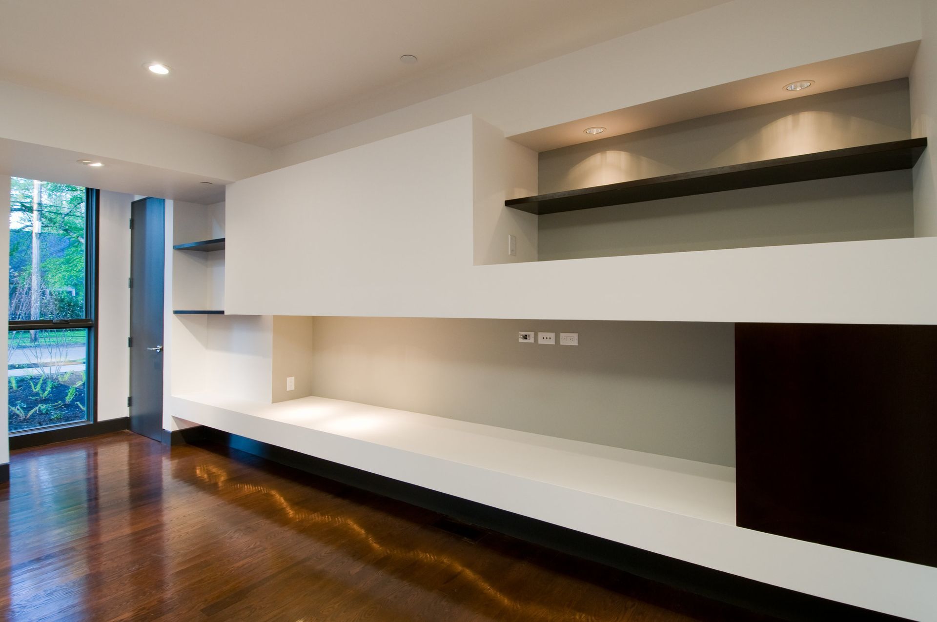 An empty room with a shelf and a window