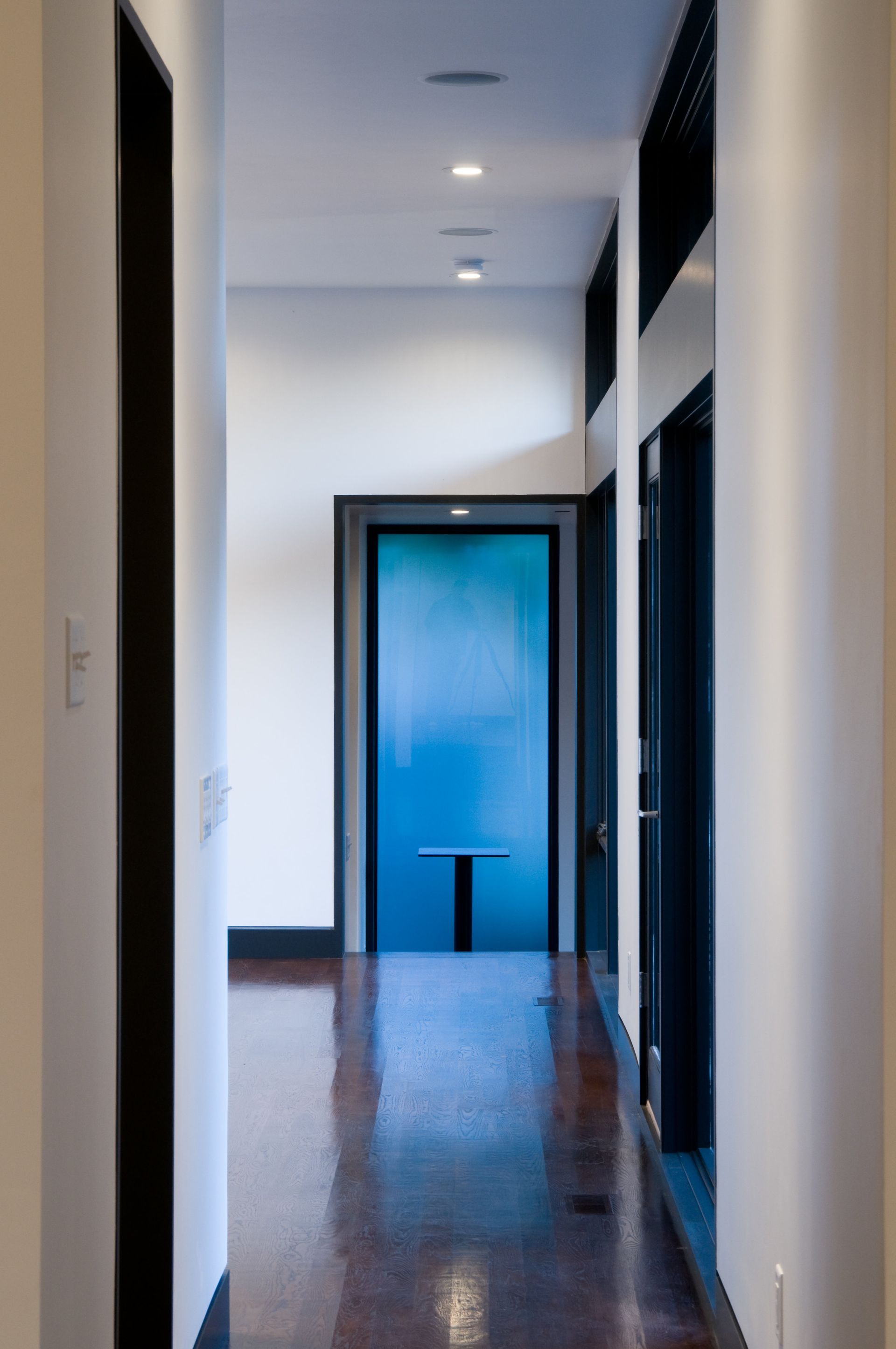 A hallway with a blue door and a table in the middle