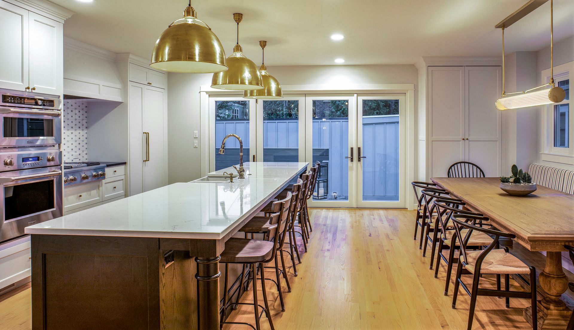 A kitchen with a large island and a long table.
