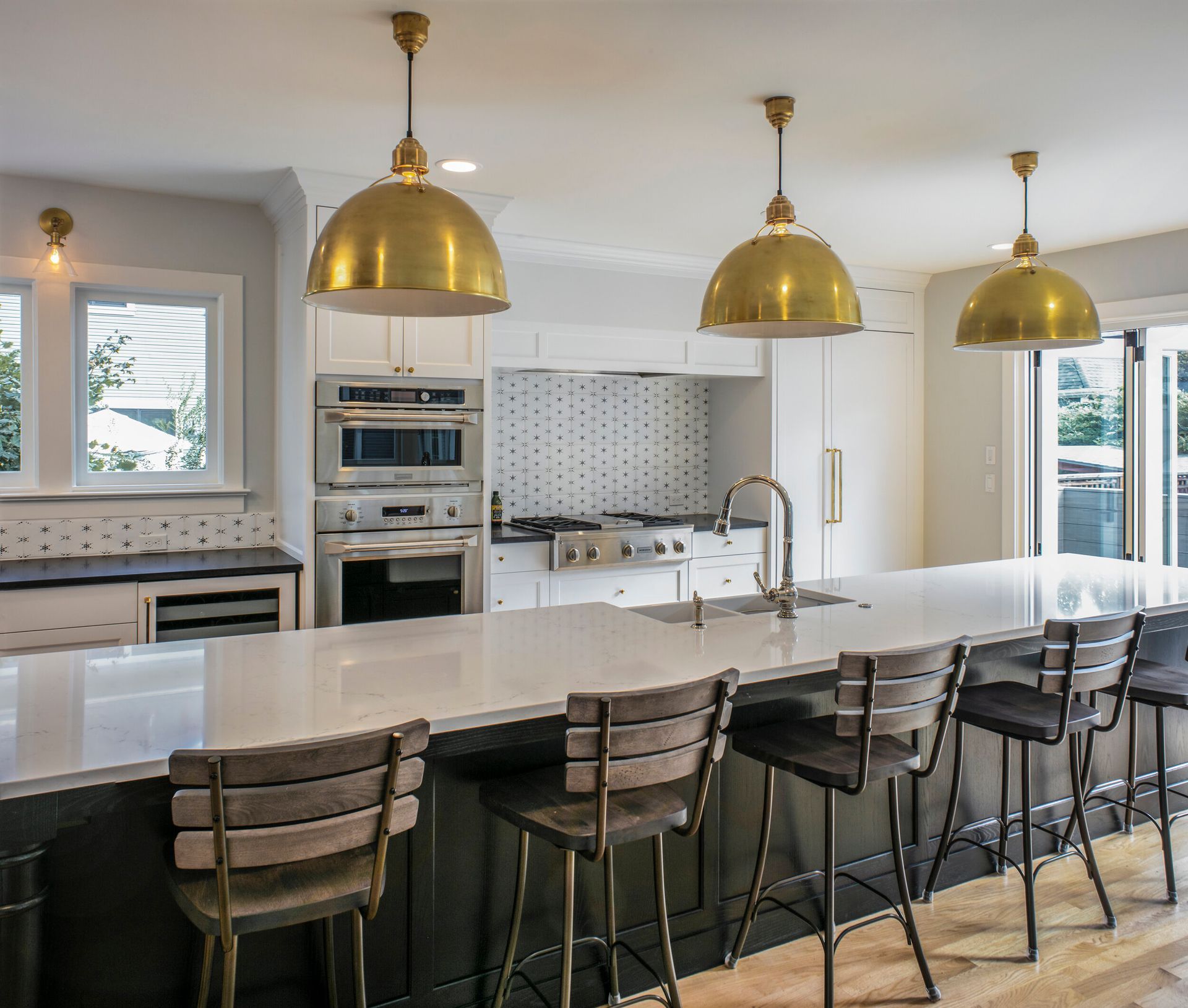 A kitchen with a long counter top and stools