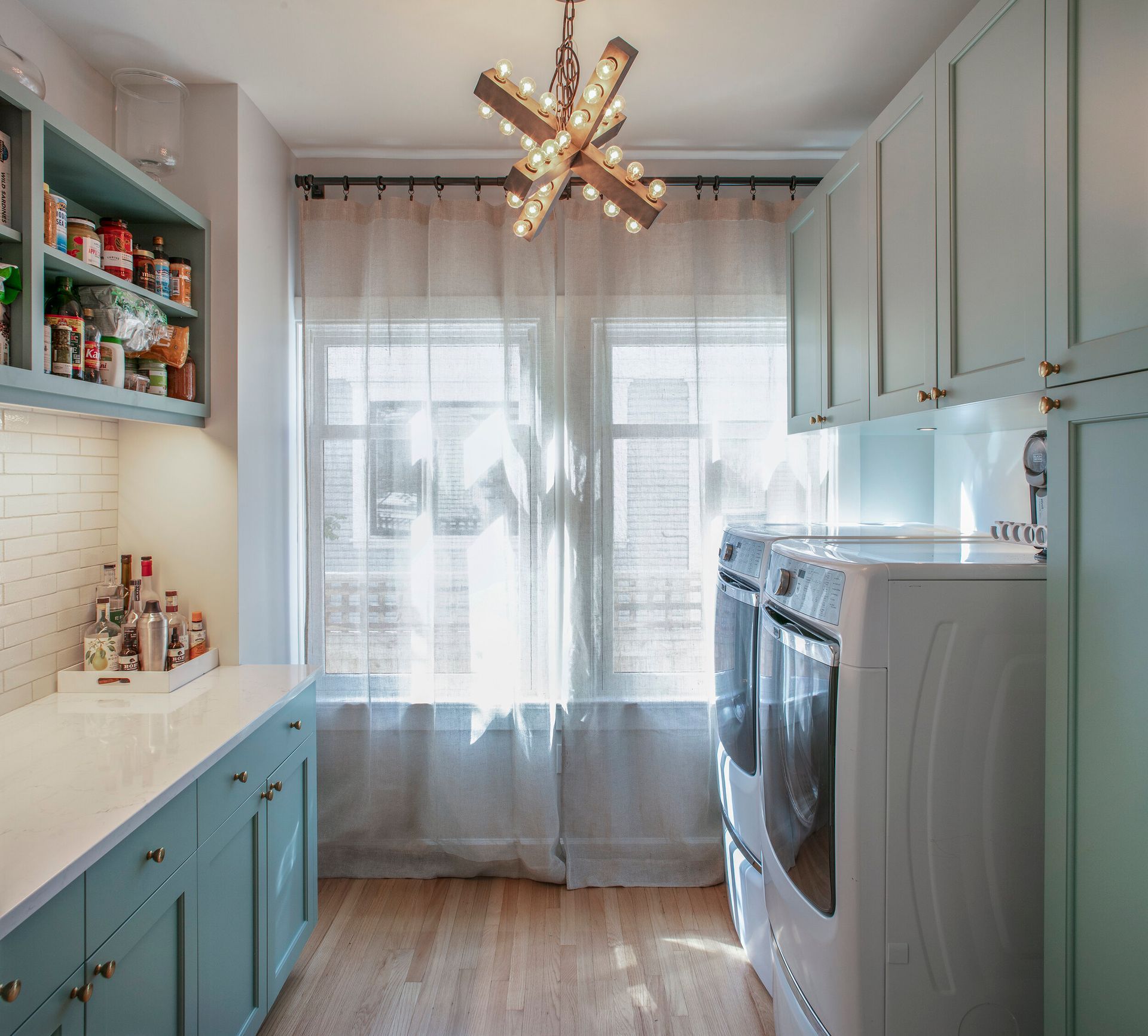 A laundry room with blue cabinets and white appliances