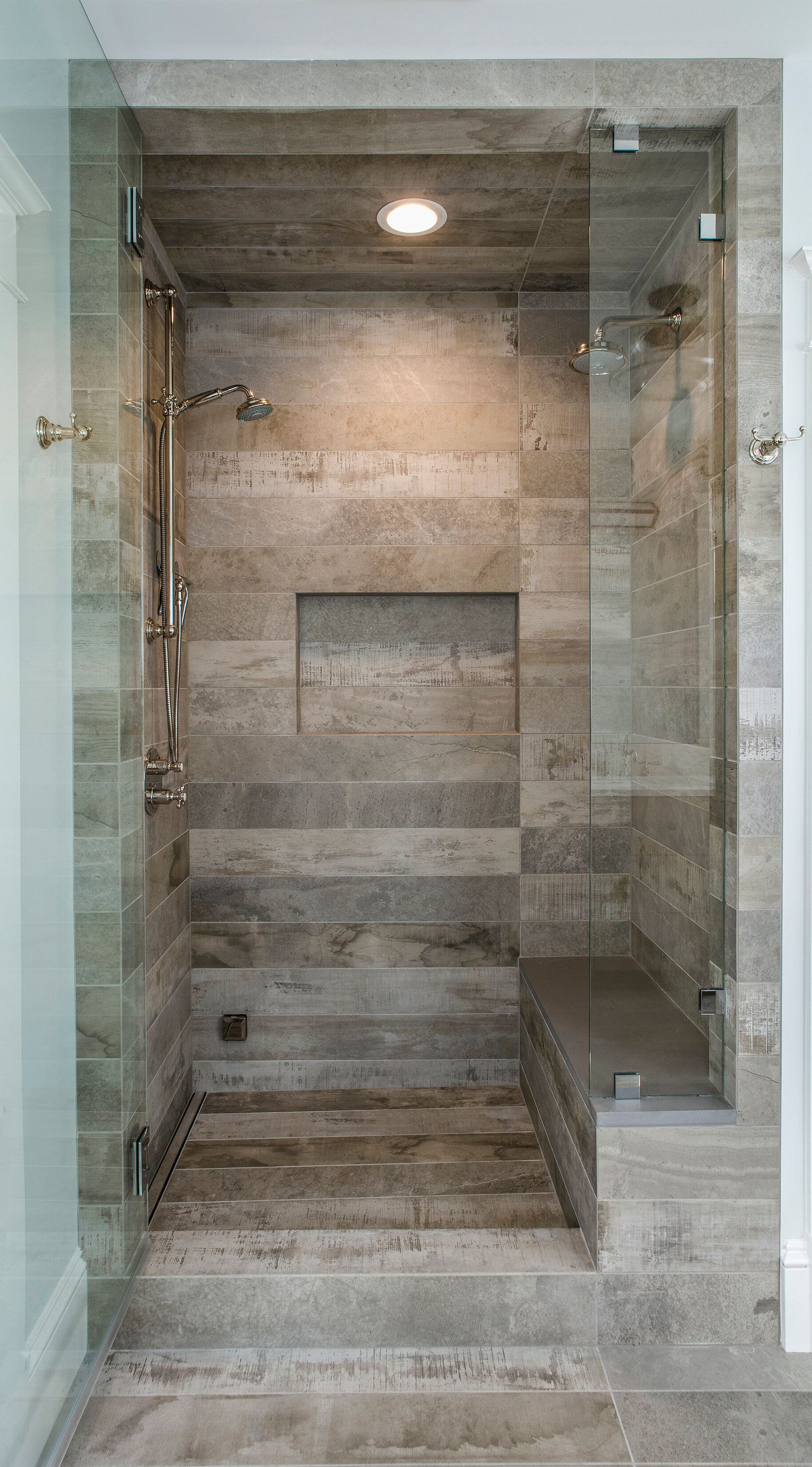A bathroom with a walk in shower with a glass door.