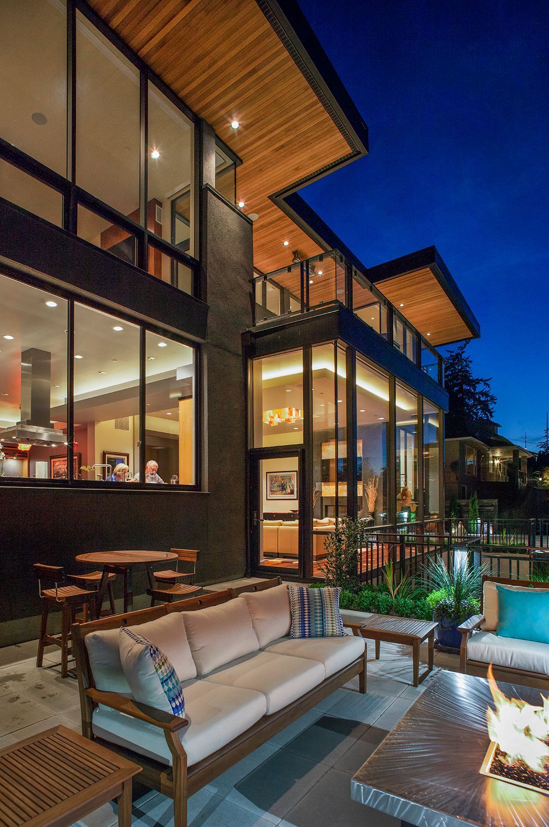 A large house with a lot of windows and a fire pit in front of it