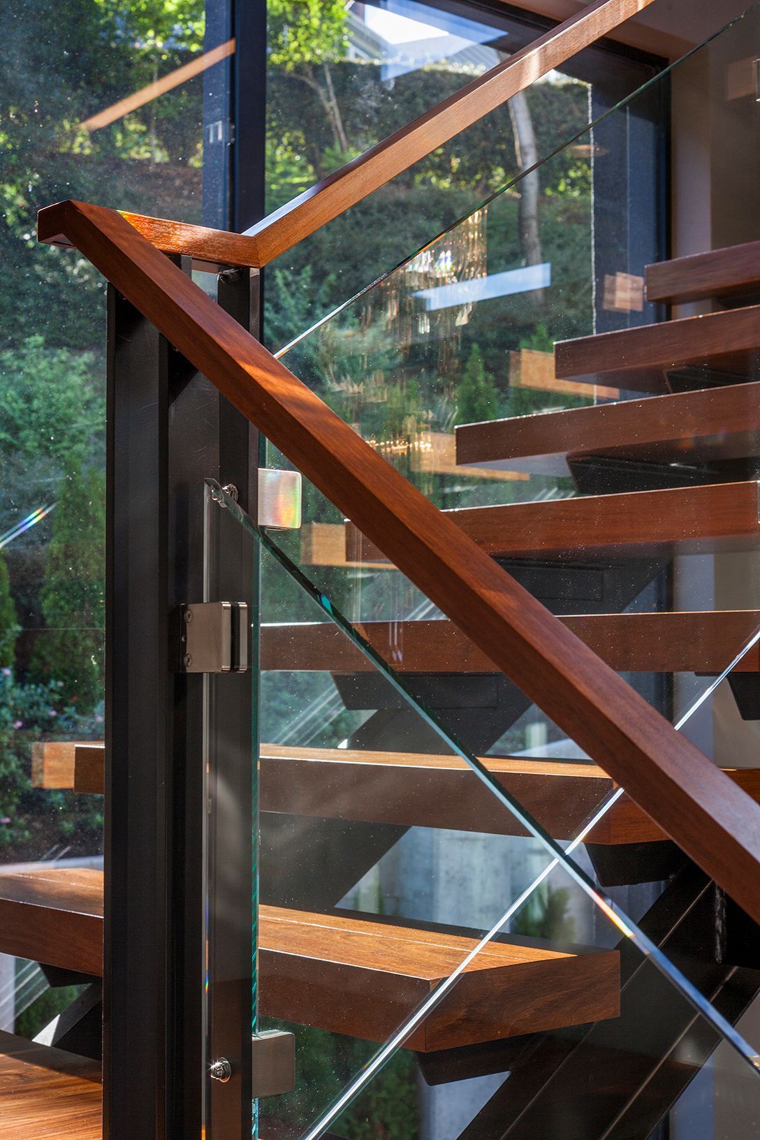 A wooden staircase with a glass railing in a house