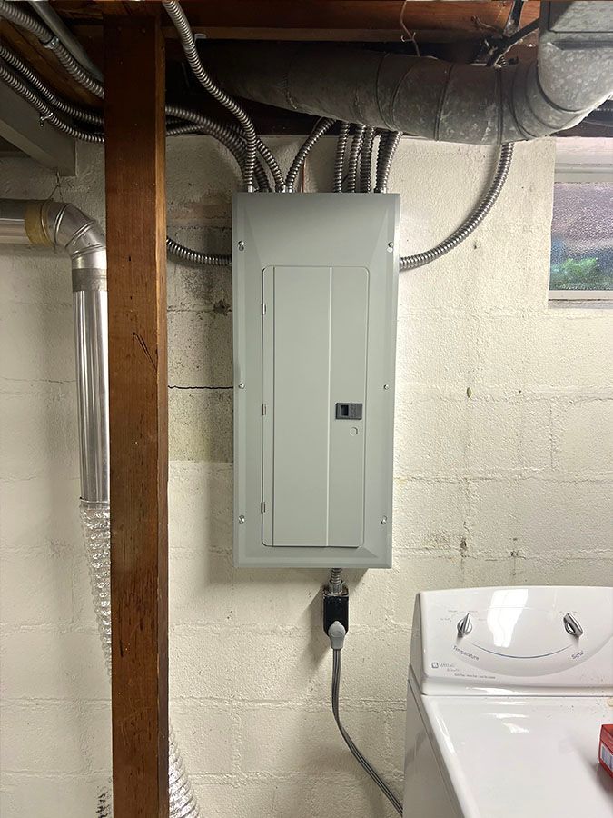 A washer and dryer are sitting in a laundry room next to an electrical box.