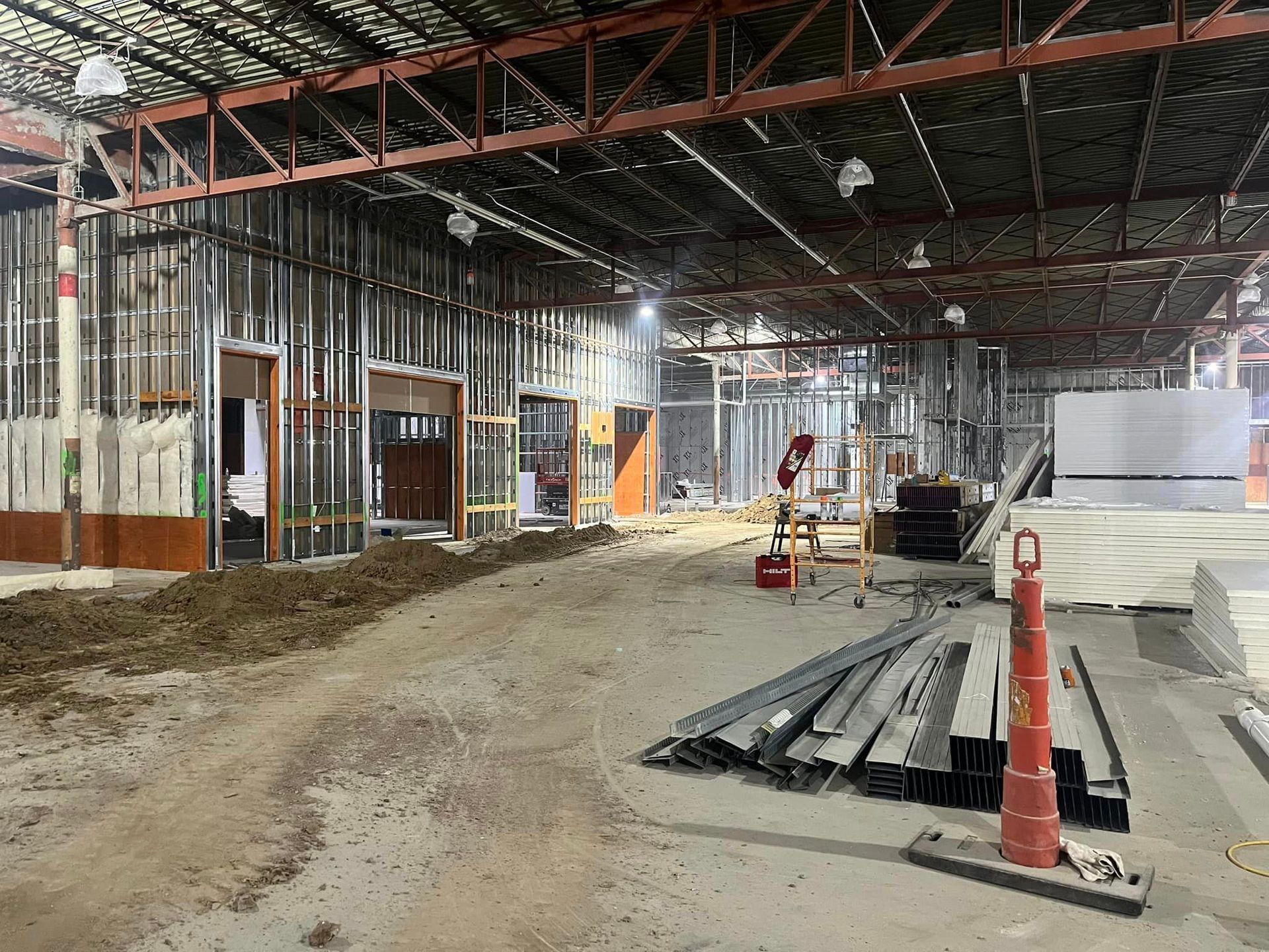 A large empty building under construction with a lot of supplies on the ground