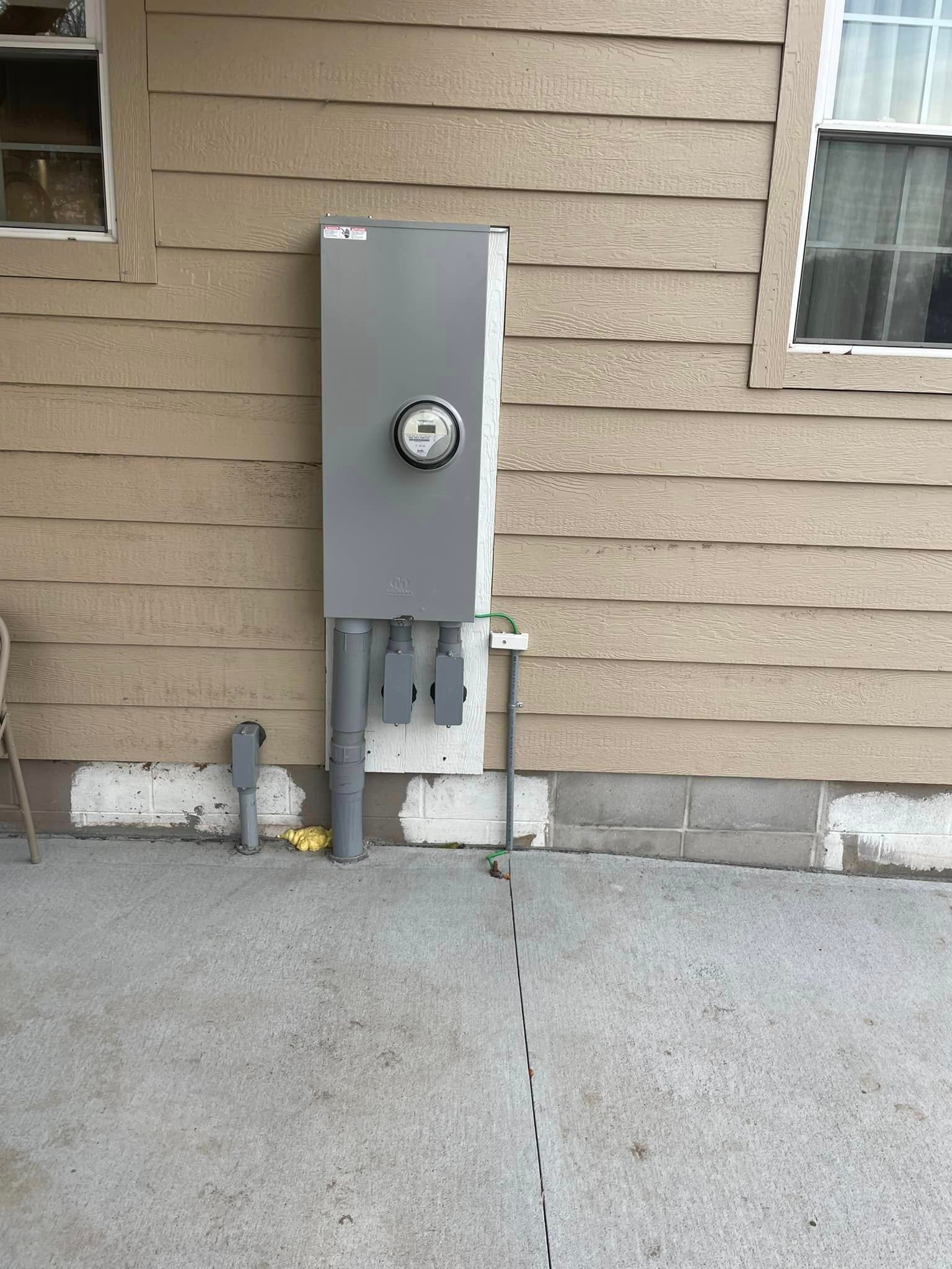 An electrical meter is installed on the side of a house
