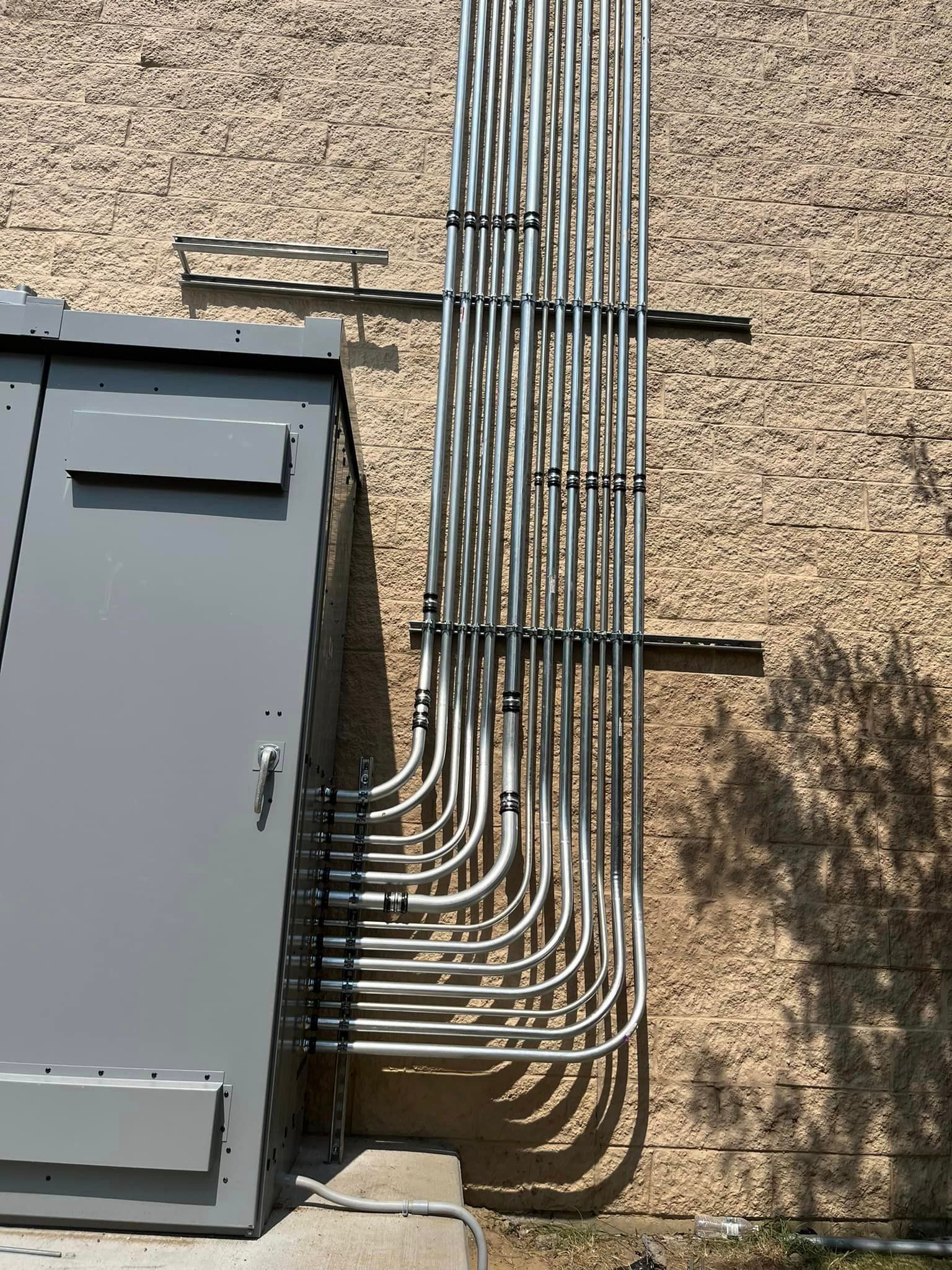 A bunch of electric metallic tubes are connected to an electrical panel box