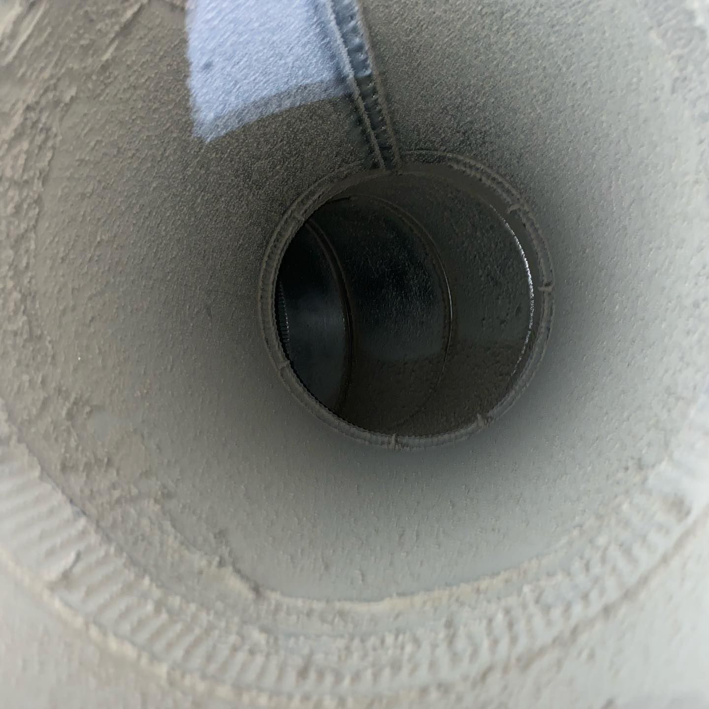 A close up of a white pipe with a hole in the middle.