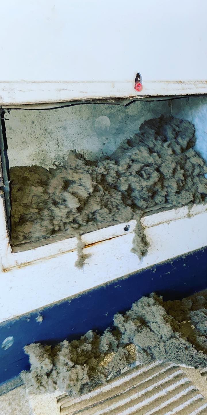 A dirty air vent with a lot of dust coming out of it.