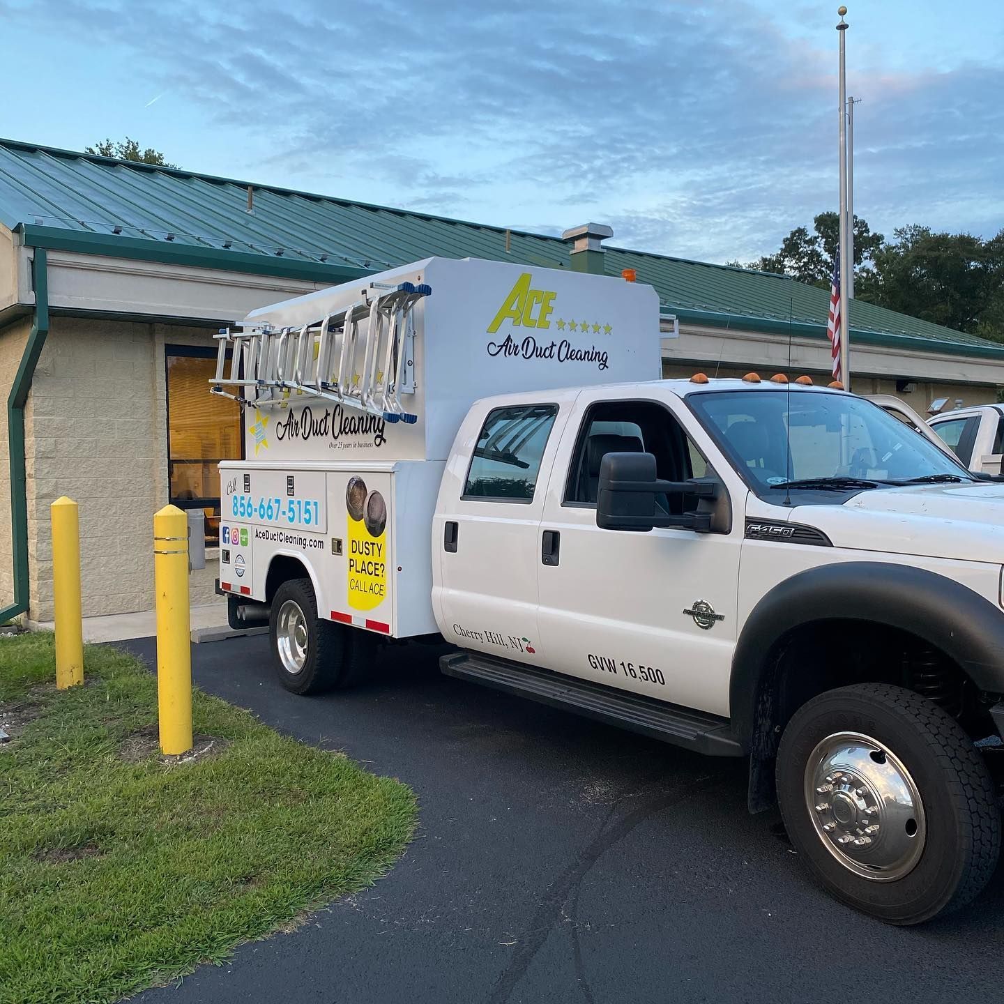 A white truck is parked in front of a building