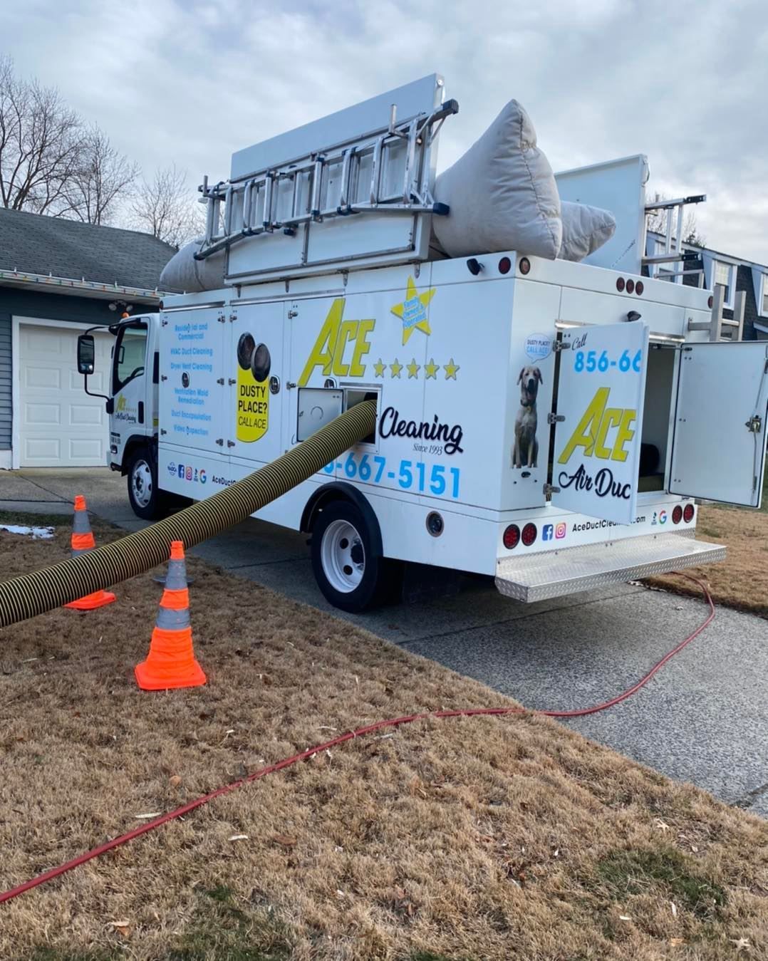 A white cleaning truck is parked in front of a house.
