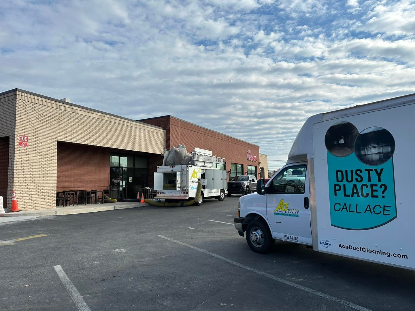 A dusty place call age truck is parked in front of a building.
