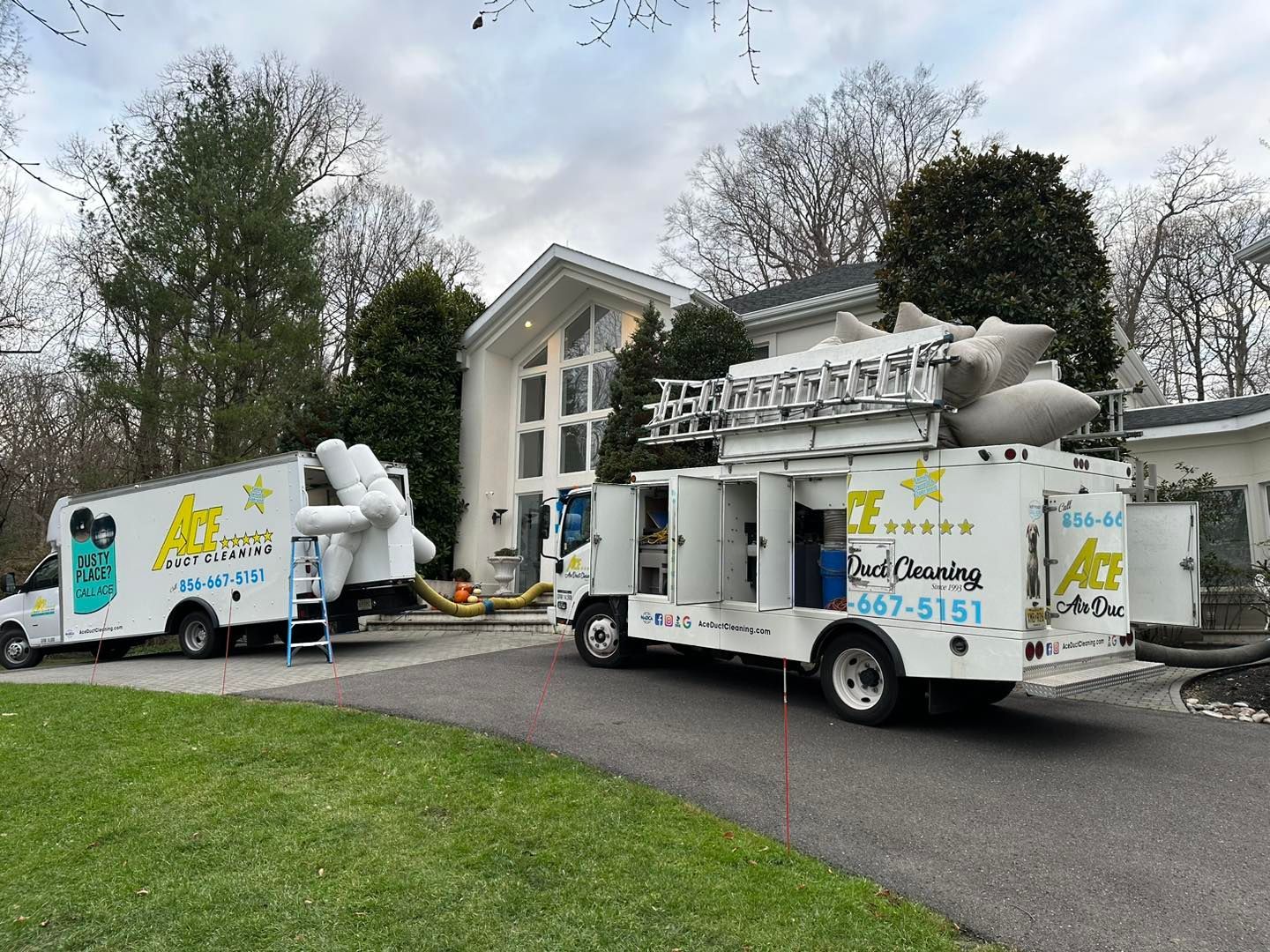 Two trucks are parked in front of a house.