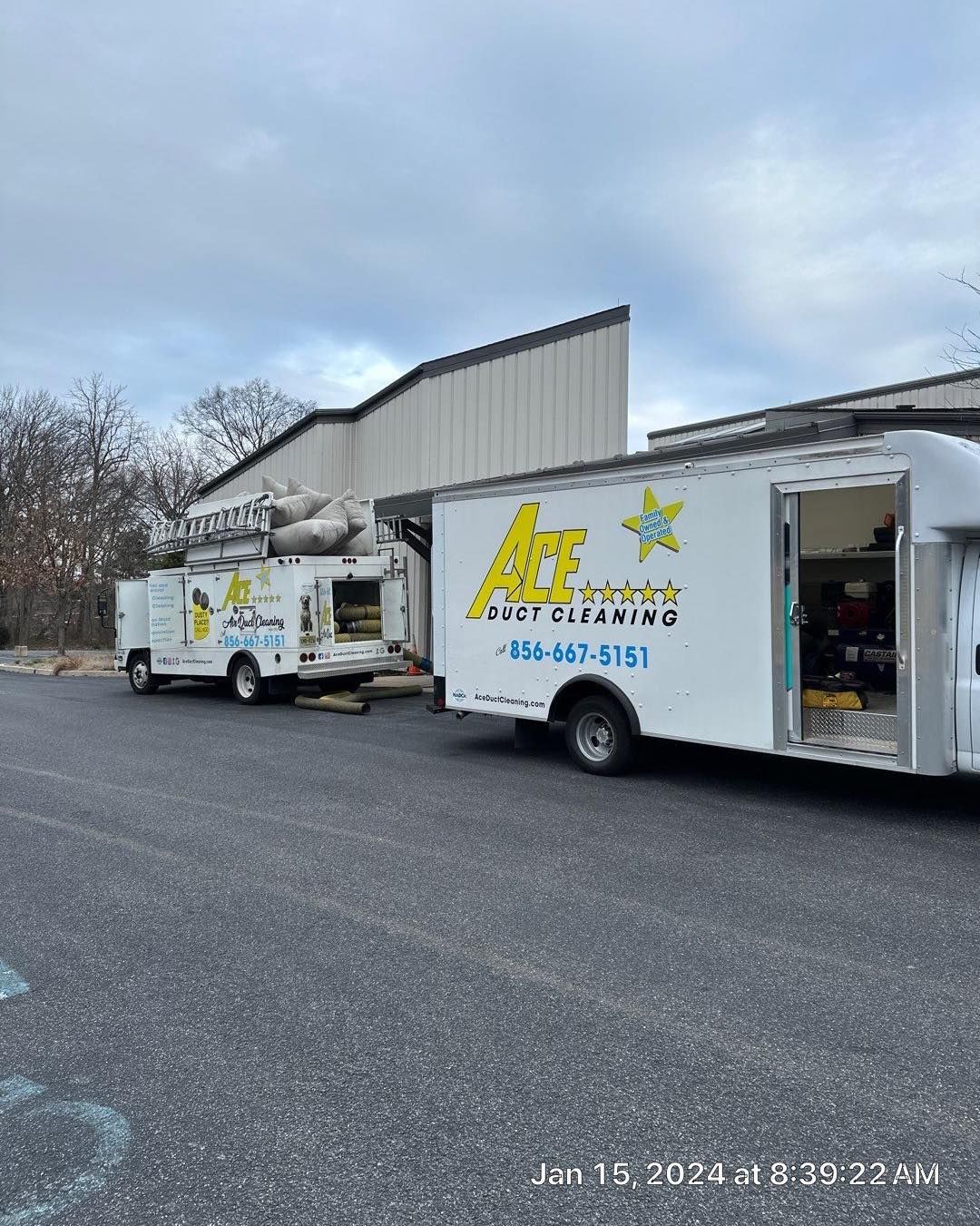 Two trucks are parked in front of a building.