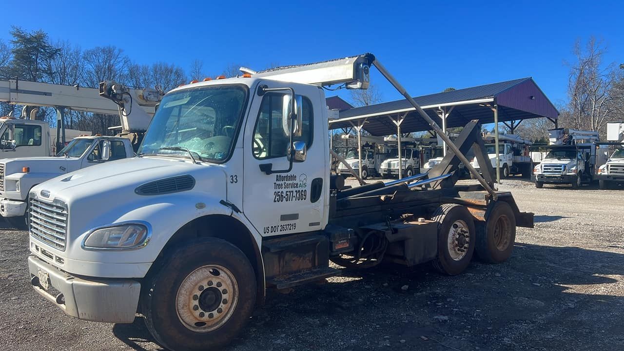 a white dump truck is parked in a gravel lot