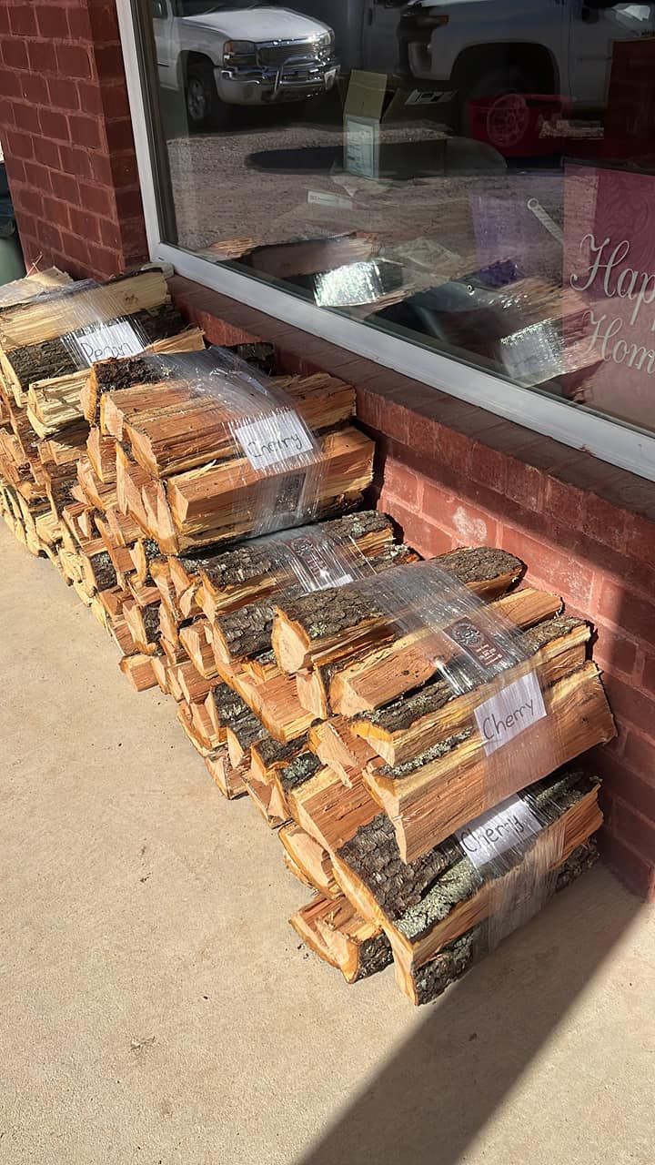 a stack of logs sitting on the sidewalk in front of a brick building