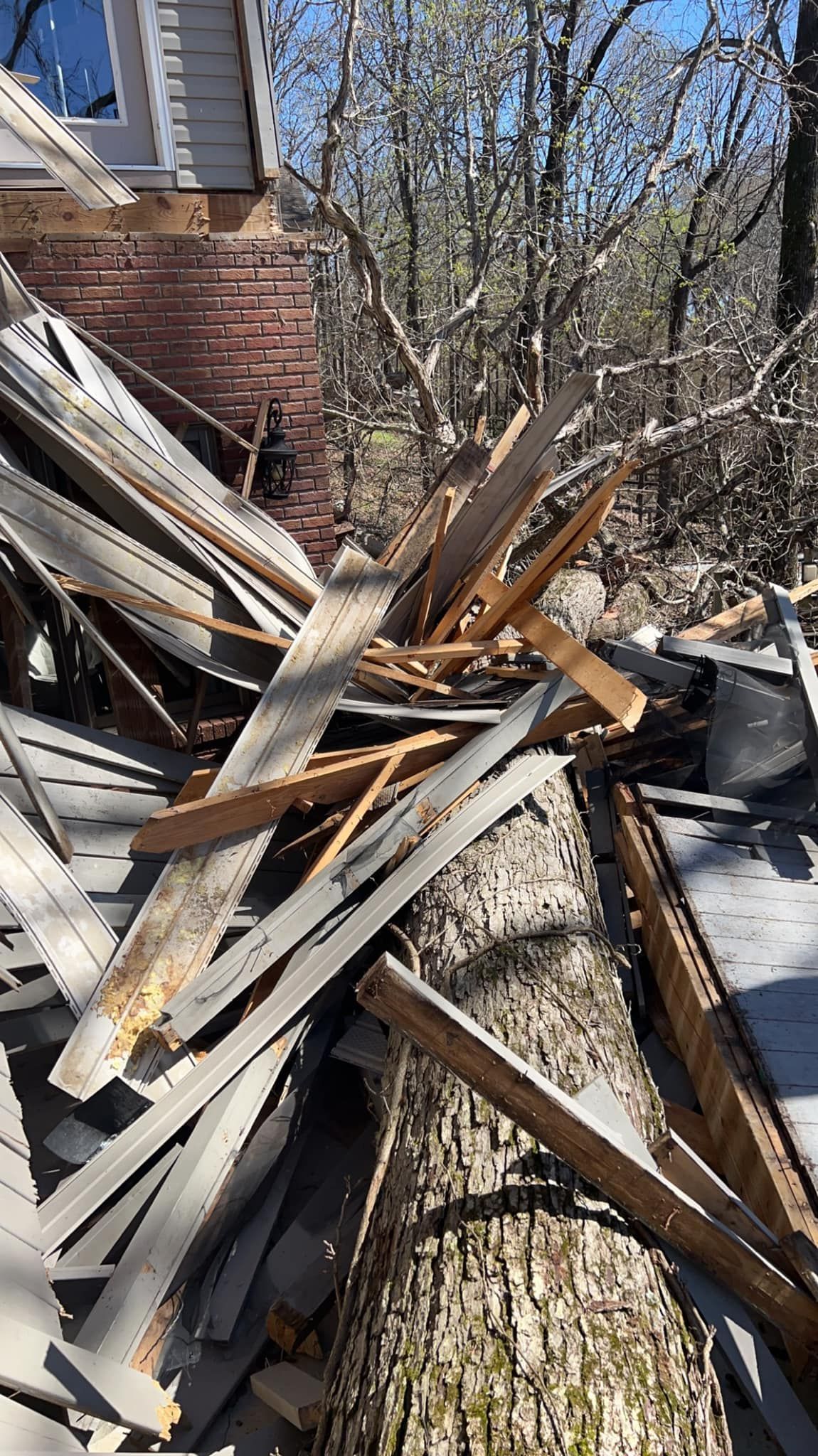 a pile of wood is sitting in front of a brick house