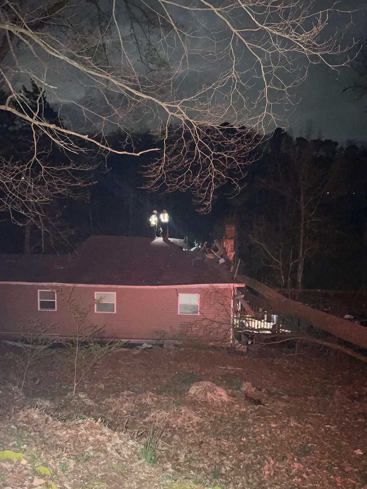 a red brick house is sitting in the middle of a field at night