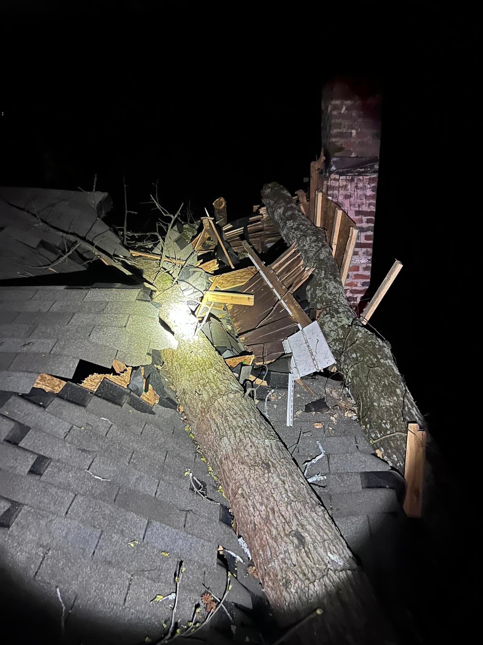 a tree stump is laying on top of a roof next to a chimney