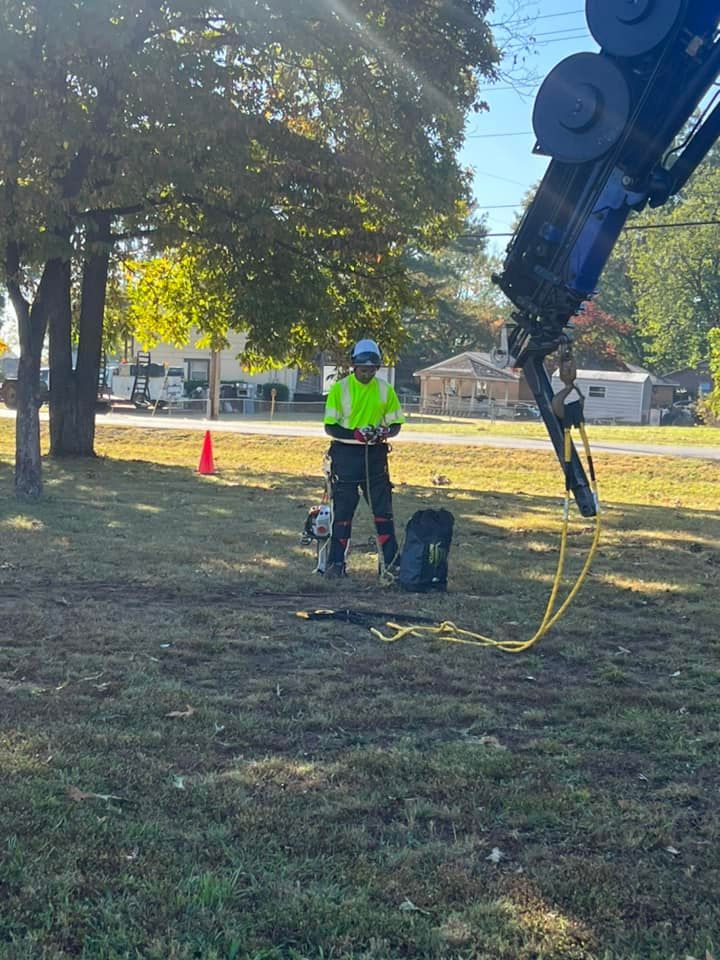 a man is standing in a field next to a crane