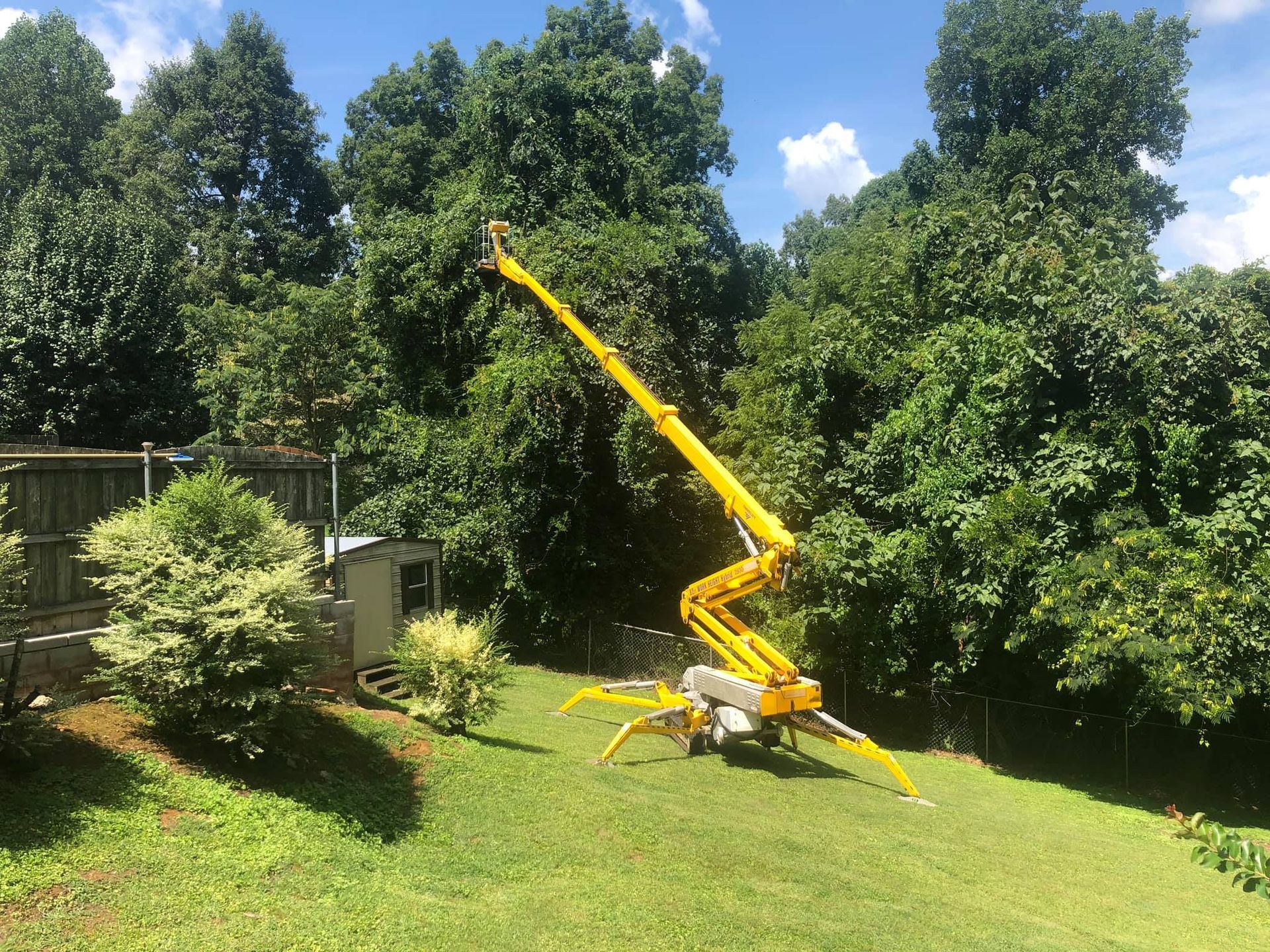 a yellow crane is sitting on top of a lush green field